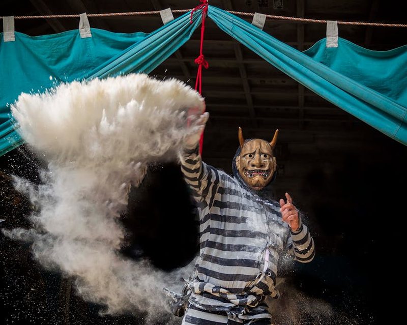 Performer wearing a traditional mask at a Japanese matsuri festival