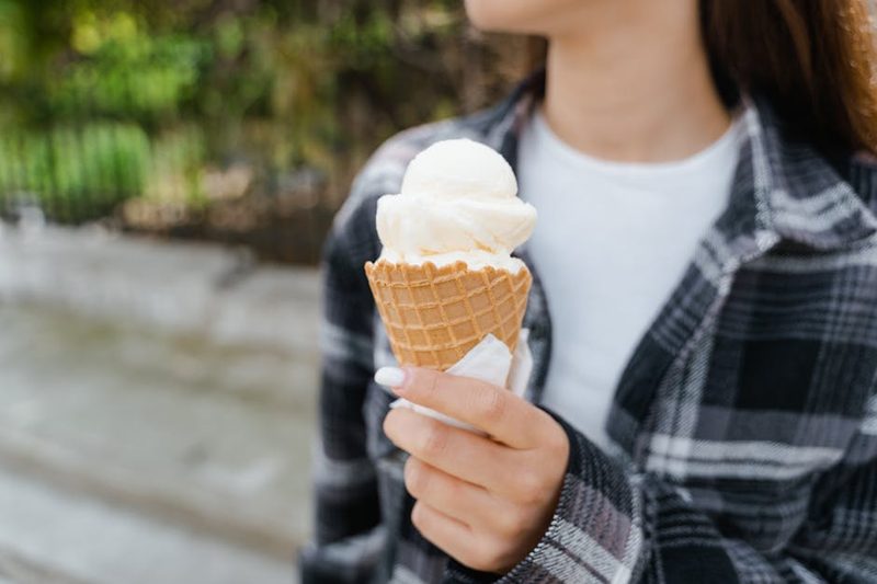 Person holding a soft serve ice cream cone