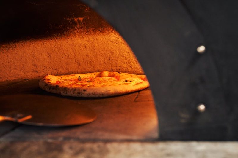 Wood-fired oven baking pizza to golden perfection