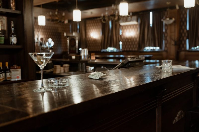 Bar counter with cocktail glasses and dim warm lighting