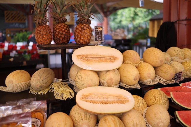Fresh melons and pineapples at an outdoor fruit market