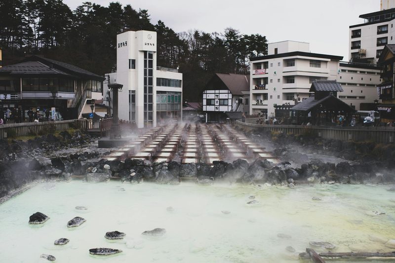 Steam rising from mineral-rich hot spring waters in a Japanese onsen town