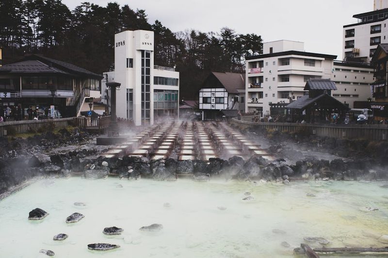 Traditional Japanese hot spring town with steam rising from mineral waters