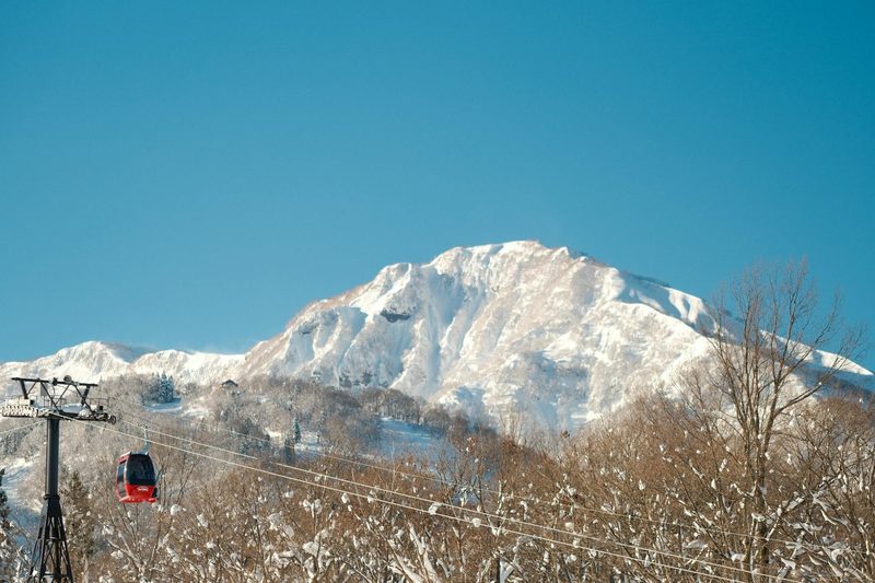 Red cable car ascending a snowy mountain at a Japanese ski resort