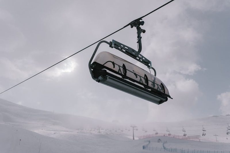 Ski lift chairs ascending a snow-covered mountain