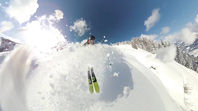 Skier on an open powder run with mountain scenery in winter